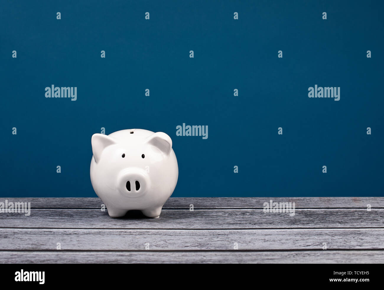 Cute white Piggy Bank over a blue and grey background Stock Photo - Alamy