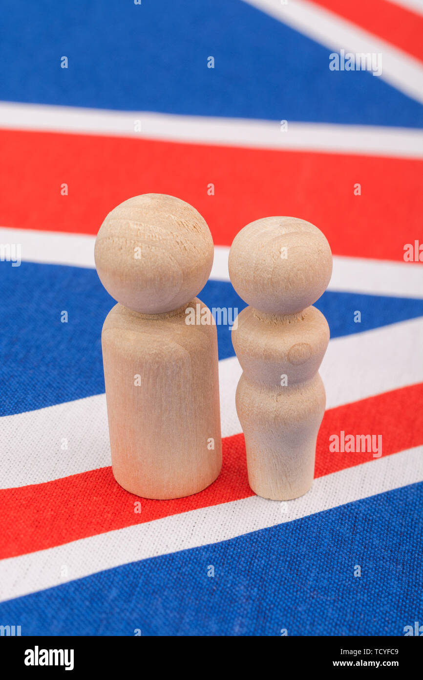 Small wooden abstract figures on Union Jack flag - representing demographic of UK family life / family unit. Stock Photo