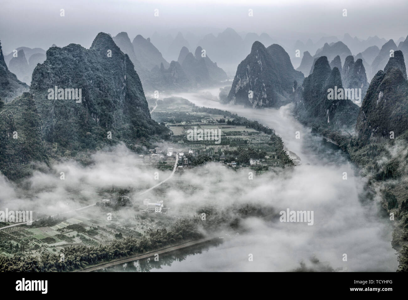 In July 2015, it was filmed in the scenic spot of Guilin City, Guangxi Zhuang Autonomous Region. In the morning, climb to the top of Xianggong to shoot beautiful scenery, look around, sunrise, sea of clouds, mountains meandering, graceful peaks, Xianggong Mountain is the best shooting place for sunrise in the Li River, every mountain, every beach of water, mountains and rivers depend on each other, strange peaks haunt. The combination of light and shadow, peak forest, clouds and fog, river water and color glow at different times, a charming landscape painting. Stock Photo