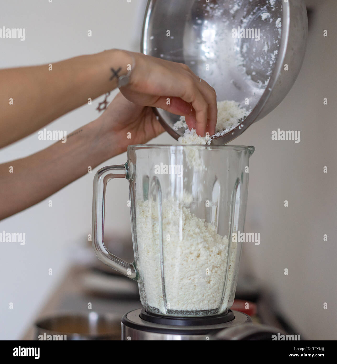 Woman Pouring Cottage Cheese Into A Blender In The Kitchen Stock