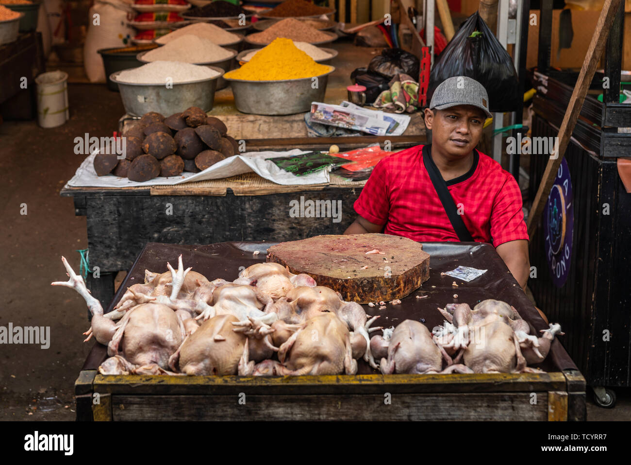 Makassar, Sulawesi, Indonesia - February 28, 2019: Terong Street Market. Ambulant vendor in red sells dead clean but whole chickens without head and f Stock Photo
