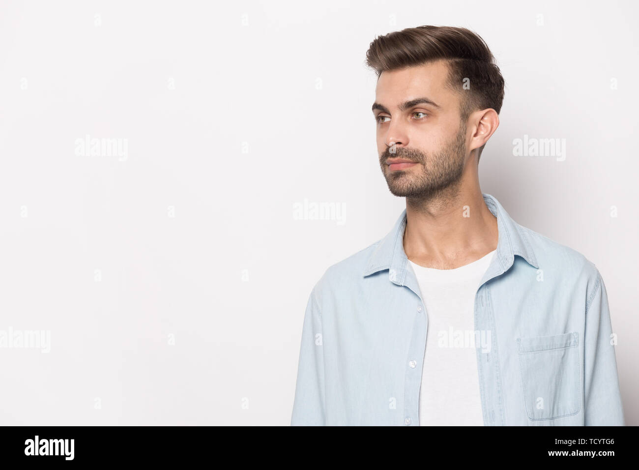 Handsome guy looking aside at copy space white studio background Stock Photo