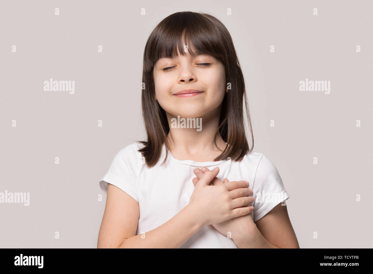 Little Girl Closed Eyes Hold Hand On Chest Feels Gratitude Stock