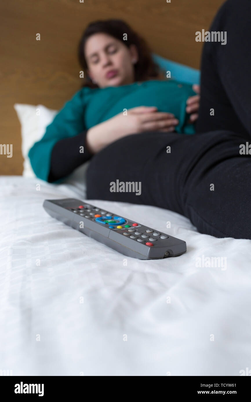Pregnant woman falling asleep while watching television Stock Photo Alamy