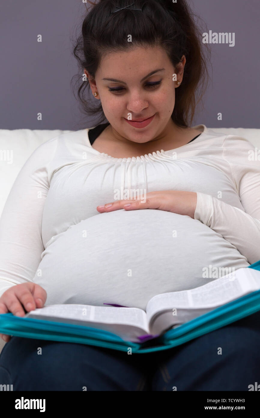 Young expectant mom reading her Bible in the morning Stock Photo