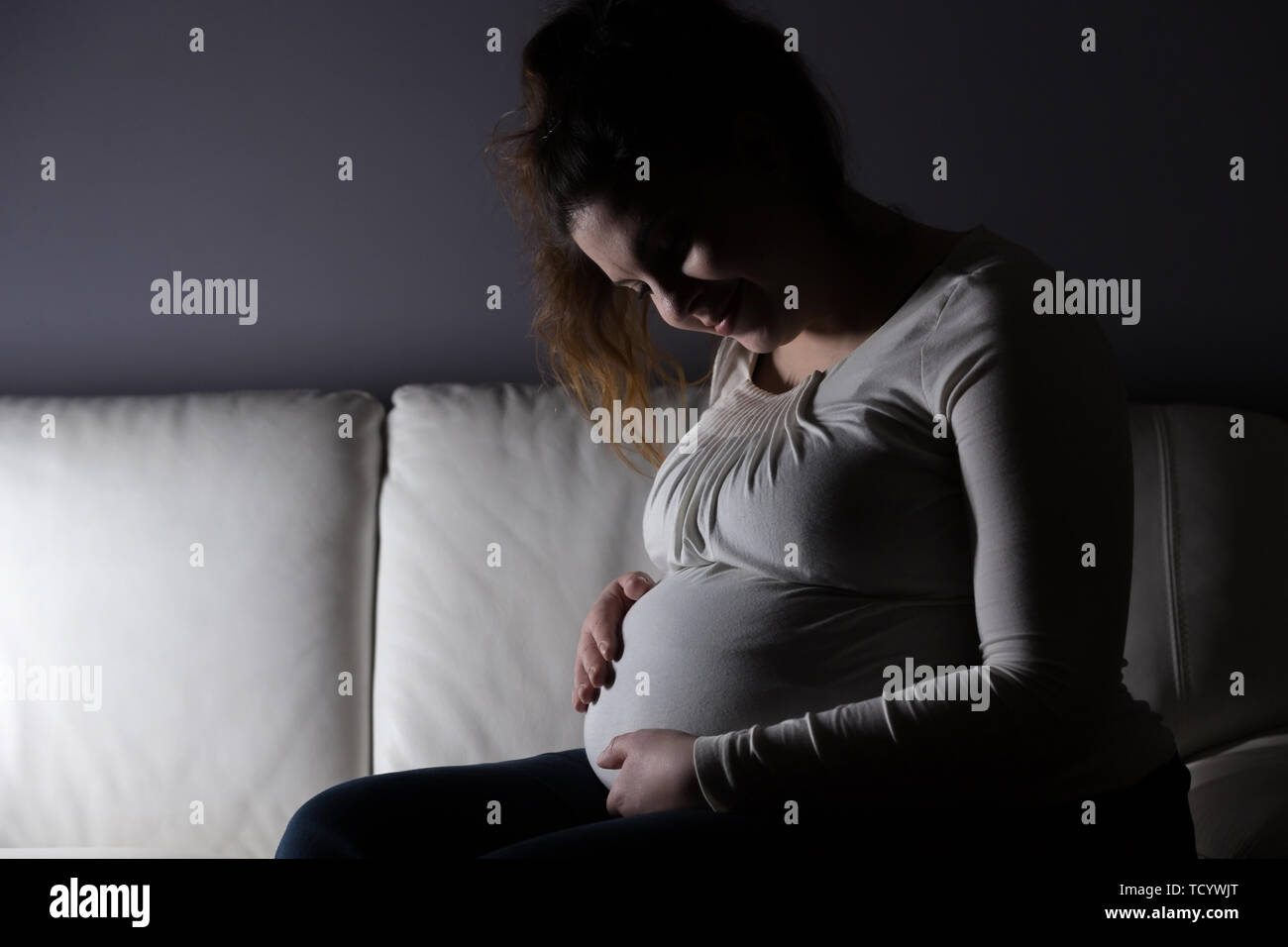 Excited Mother lovingly holding unborn child Stock Photo