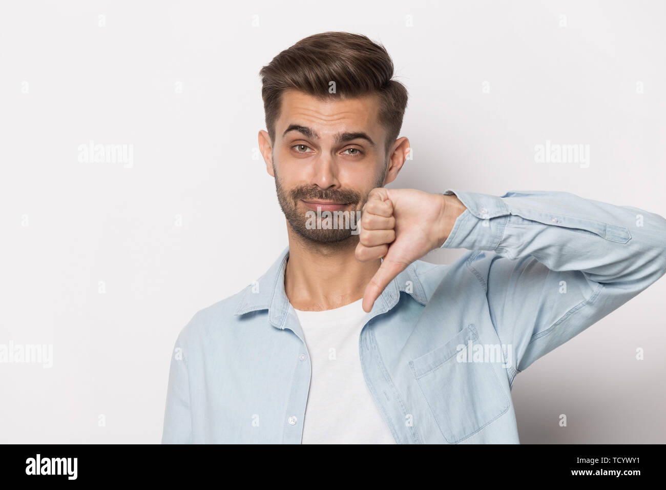 Millennial guy showing thumbs down studio head shot Stock Photo Alamy