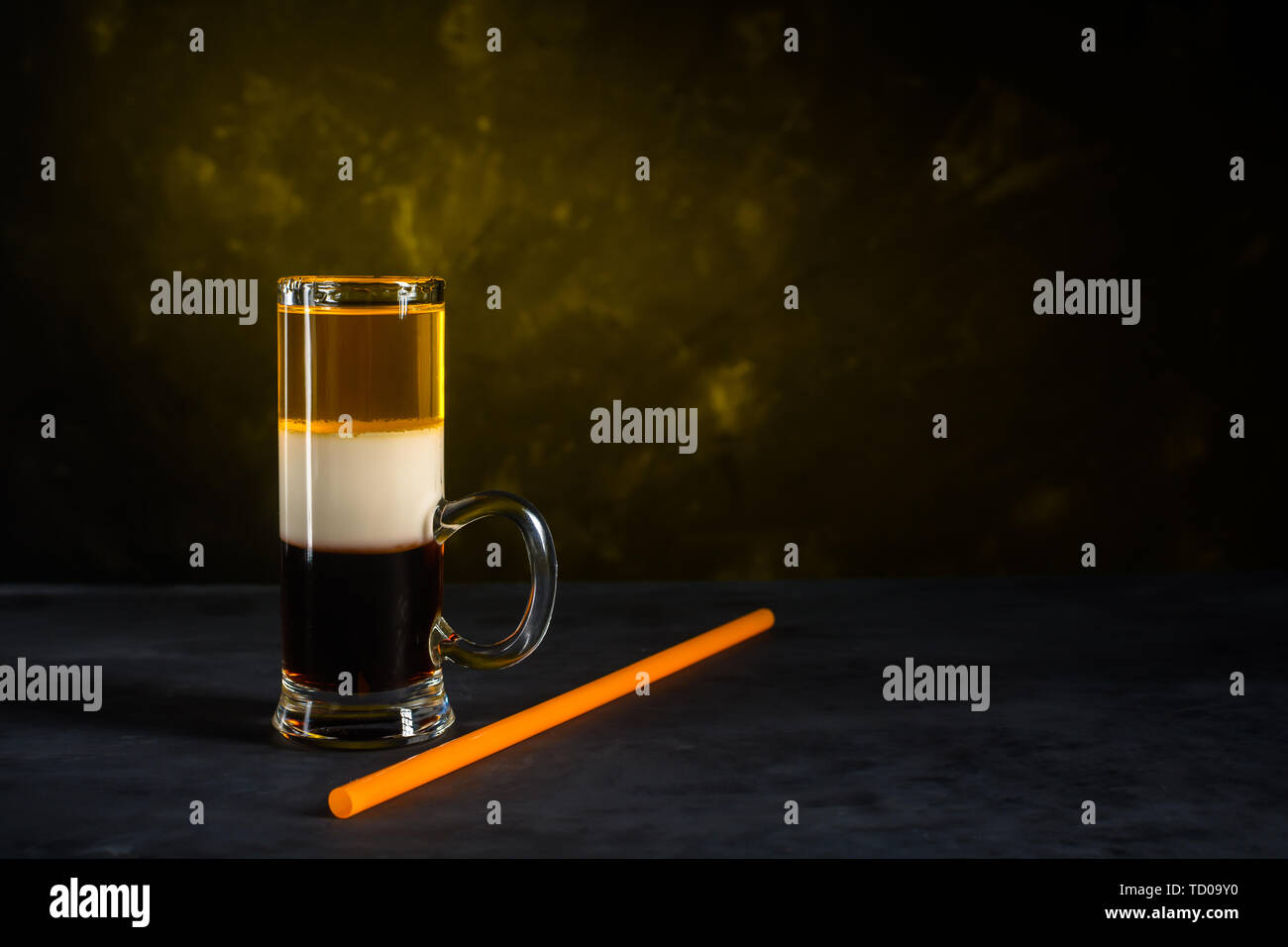 B-52 cocktail shot and straw on dark concrete background Stock Photo
