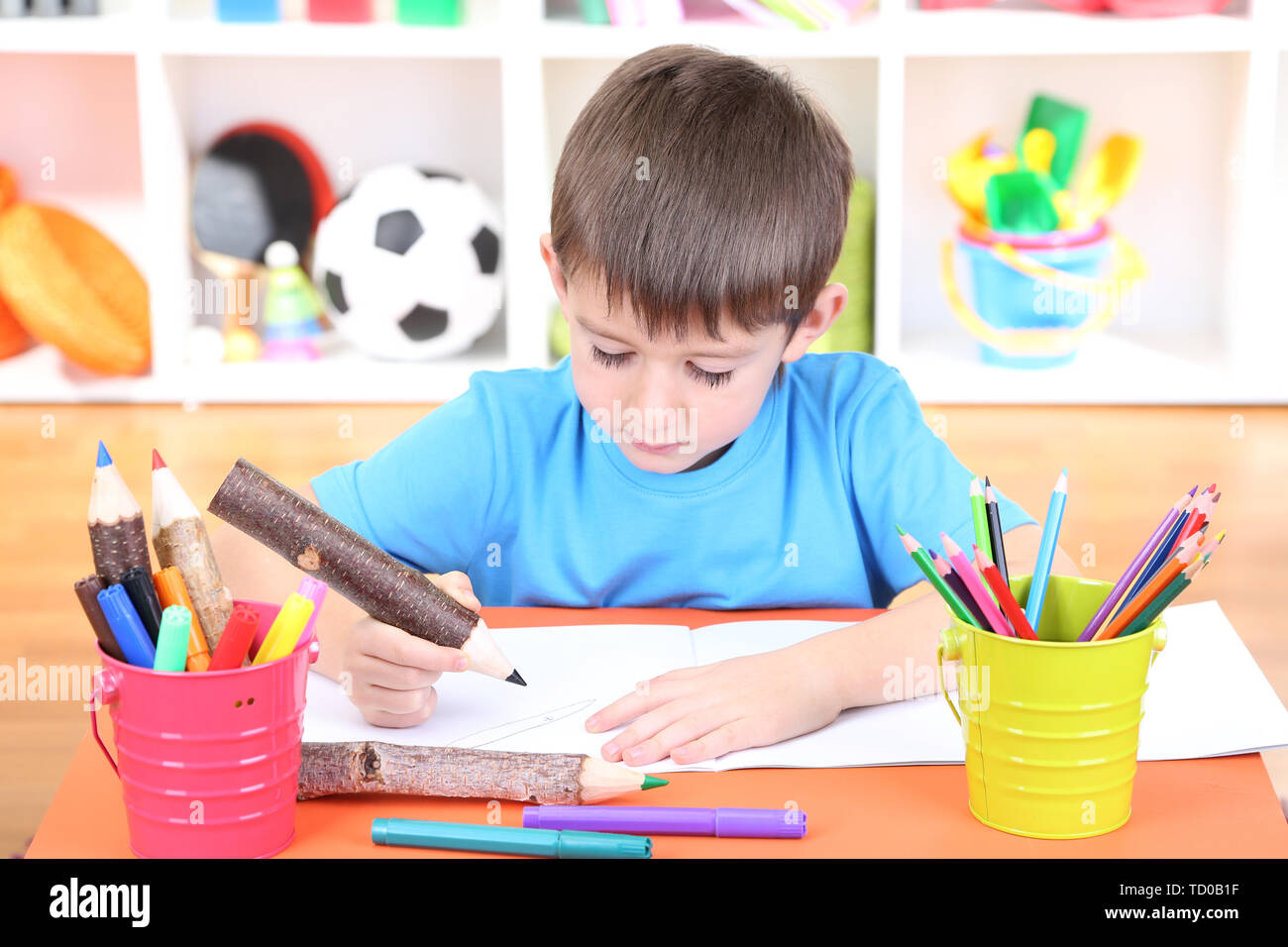 Cute little boy drawing in his album Stock Photo - Alamy