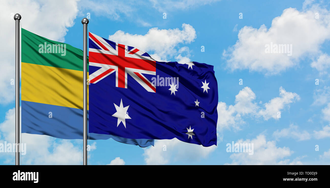 Gabon and Australia flag waving in the wind against white cloudy blue sky together. Diplomacy concept, international relations. Stock Photo