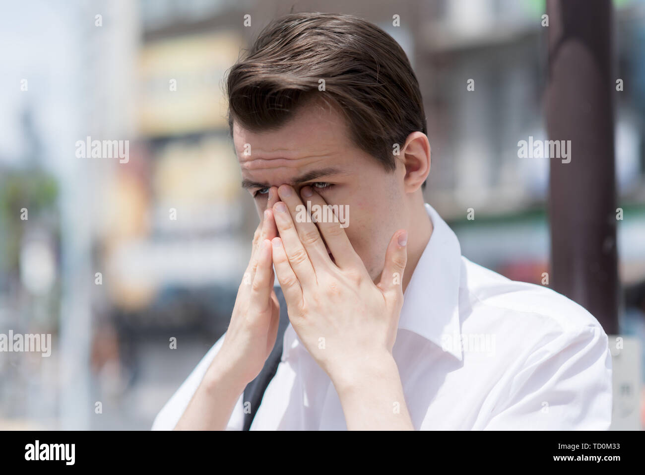 A young man has Itchy, watery, swollen eyes due to pollen allergy Stock
