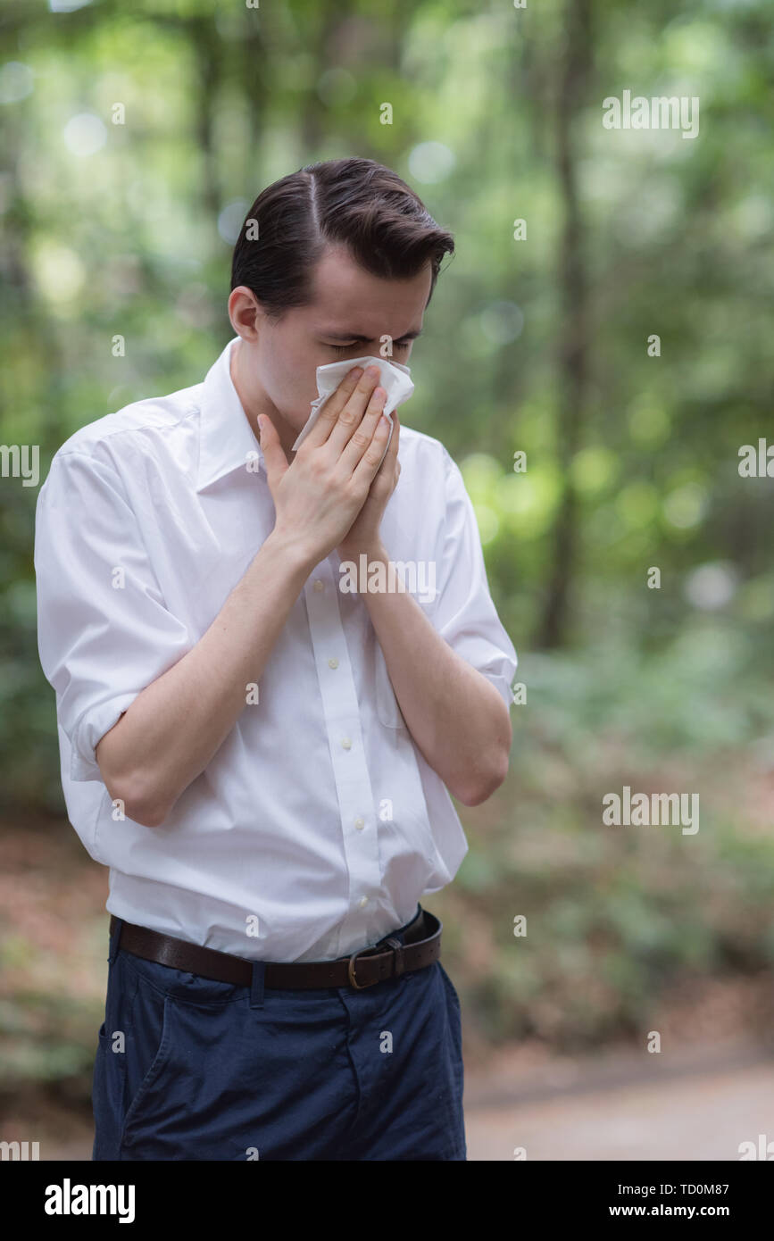 Man uses tissue paper sneezing due to having pollen allergy Stock Photo