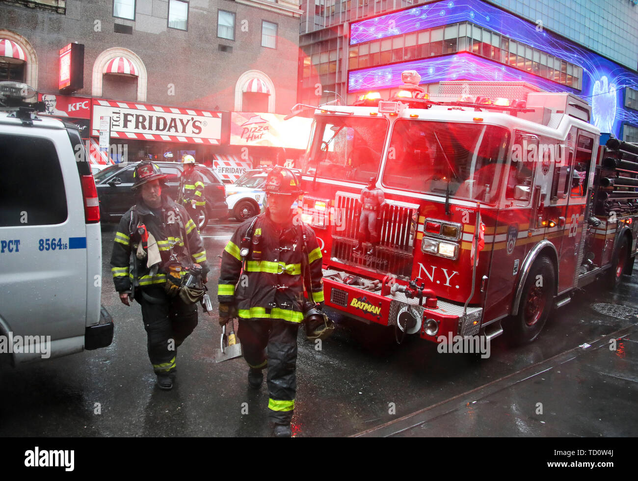 Beijing, USA. 10th June, 2019. Fire fighters walk on the street near the building where a helicopter made a force landing in Manhattan, New York, the United States, June 10, 2019. One person was killed after a helicopter made a force landing onto the roof of a skyscraper in Midtown Manhattan of New York City Monday afternoon, according to authorities. Credit: Wang Ying/Xinhua/Alamy Live News Stock Photo