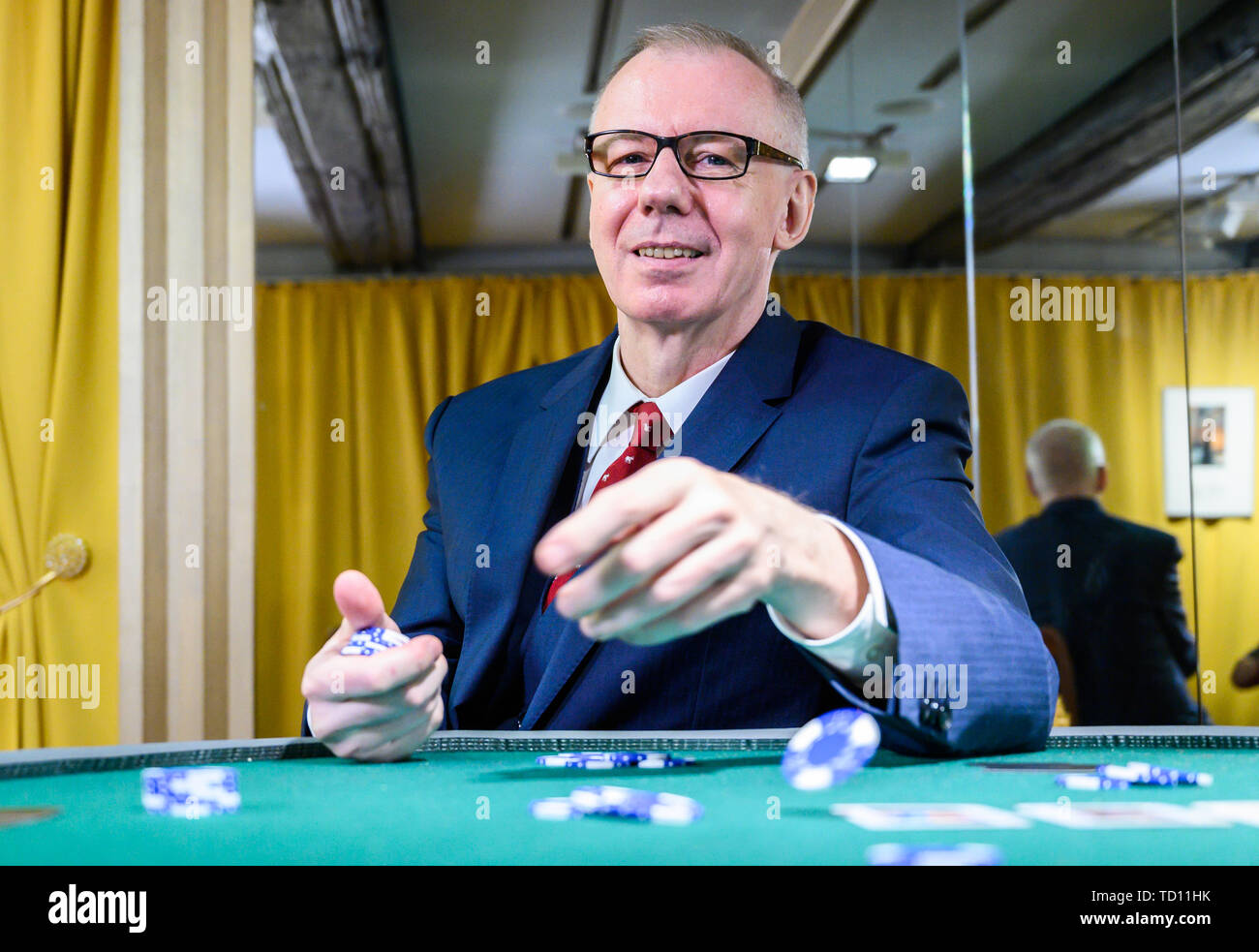 Hameln, Germany. 11th June, 2019. Ludger Pistor, actor in the James Bond film 'Casino Royale' (2006) as Swiss private banker 'Herr Mendel', sits in the exhibition 'James Bond. The power of seduction' in the Museum Hameln at a casino table. The exhibition will run from 12 June 2019 to 10 May 2020. Credit: Christophe Gateau/dpa/Alamy Live News Stock Photo