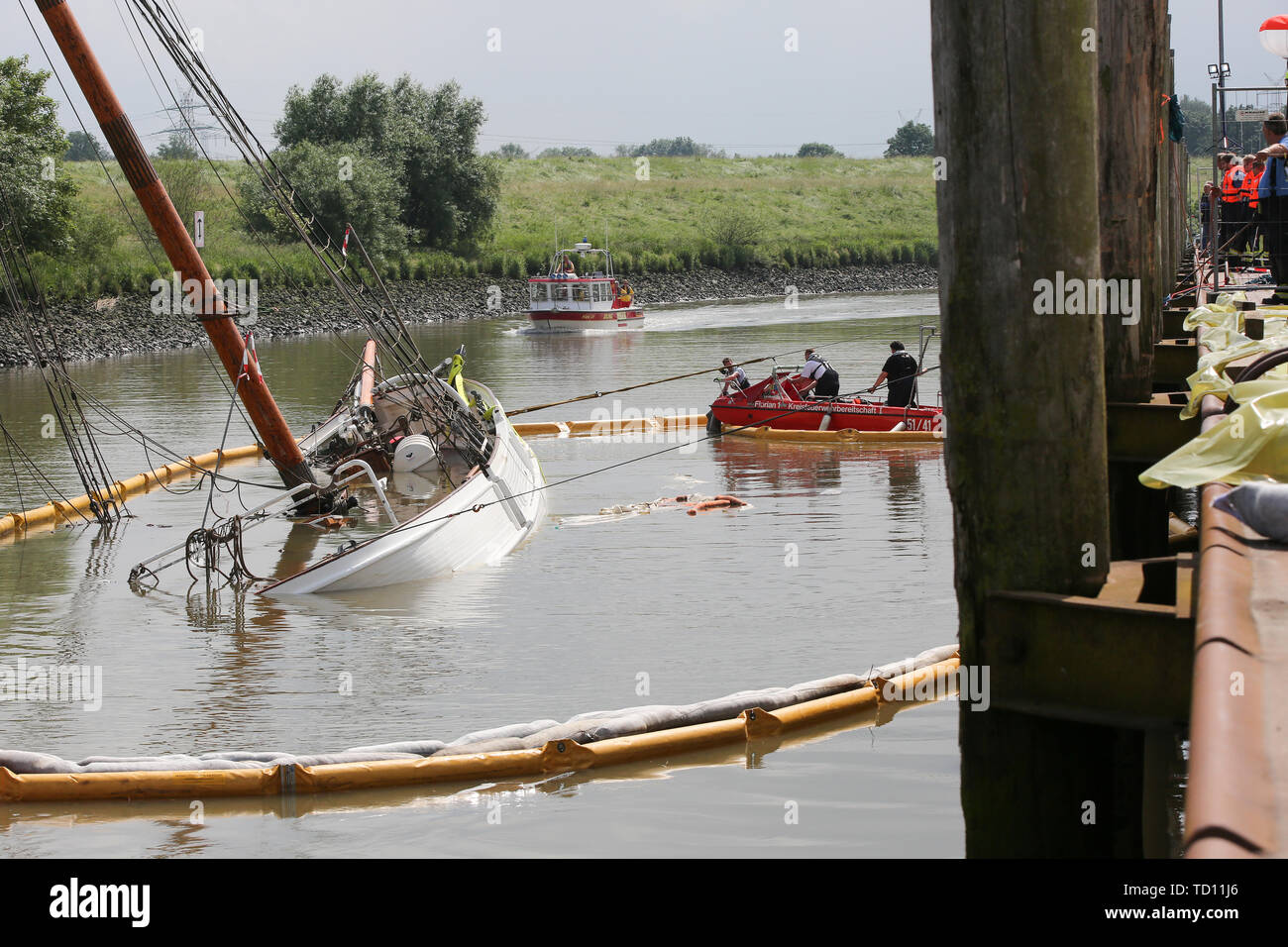 Stadersand, Germany. 11th June, 2019. Emergency forces are preparing the laying of new oil barriers around the sunken historic sailing ship 'No 5 Elbe' in the harbour of Stadersand. Operating fluids had leaked from the hull of the sailing ship, and the fire brigade was on site with the support of the German Federal Agency for Technical Relief and the German Aerospace Center (DLRG). The historic sailing ship, which has only recently been extensively renovated, collided with a container ship on the Elbe and sank. Credit: Bodo Marks/dpa/Alamy Live News Stock Photo