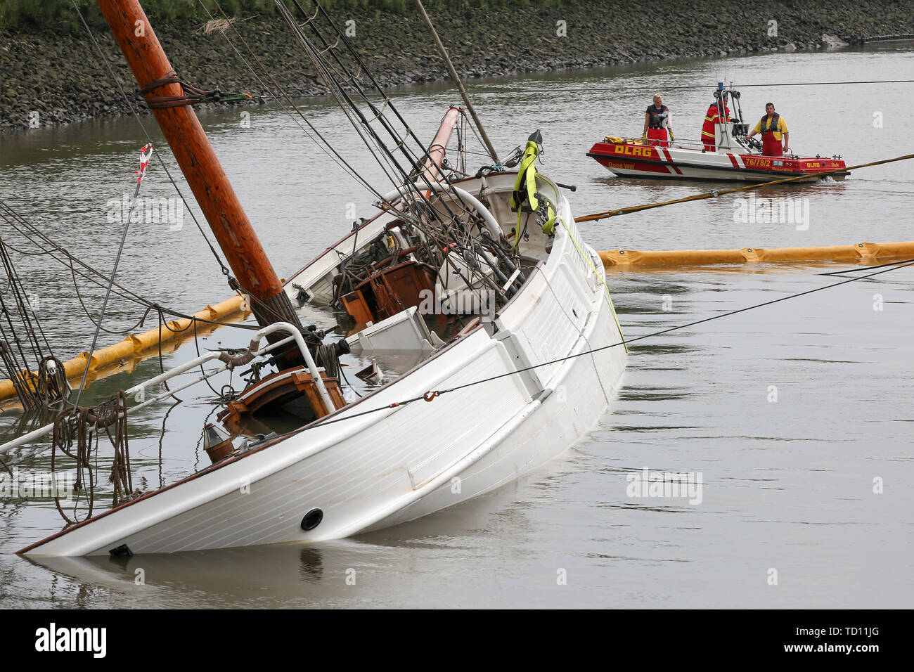 Stadersand, Germany. 11th June, 2019. Emergency forces are preparing the laying of new oil barriers around the sunken historic sailing ship 'No 5 Elbe' in the harbour of Stadersand. Operating fluids had leaked from the hull of the sailing ship, and the fire brigade was on site with the support of the German Federal Agency for Technical Relief and the German Aerospace Center (DLRG). The historic sailing ship, which has only recently been extensively renovated, collided with a container ship on the Elbe and sank. Credit: Bodo Marks/dpa/Alamy Live News Stock Photo