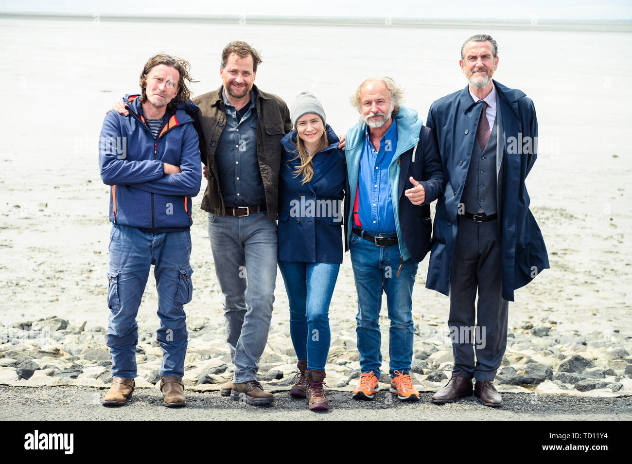 Norddeich, Germany. 11th June, 2019. Martin Lehwald (producer; l-r), Christian Erdmann (as Frank Eller), Julia Jentsch (as Ann Kathrin Klaasen), Klaus-Peter Wolf (book author), and Kai Maertens (Ubbo Heide) stand grouped for a photo at the dyke during the press conference for the Saturday thriller 'Ostfriesengrab'. The fourth film in the Ostfriesland crime series is based on the novel of the same name by Klaus-Peter Wolf (about dpa 'successful author Klaus-Peter Wolf provides material for new ZDF crime thriller'). Credit: Mohssen Assanimoghaddam/dpa/Alamy Live News Stock Photo
