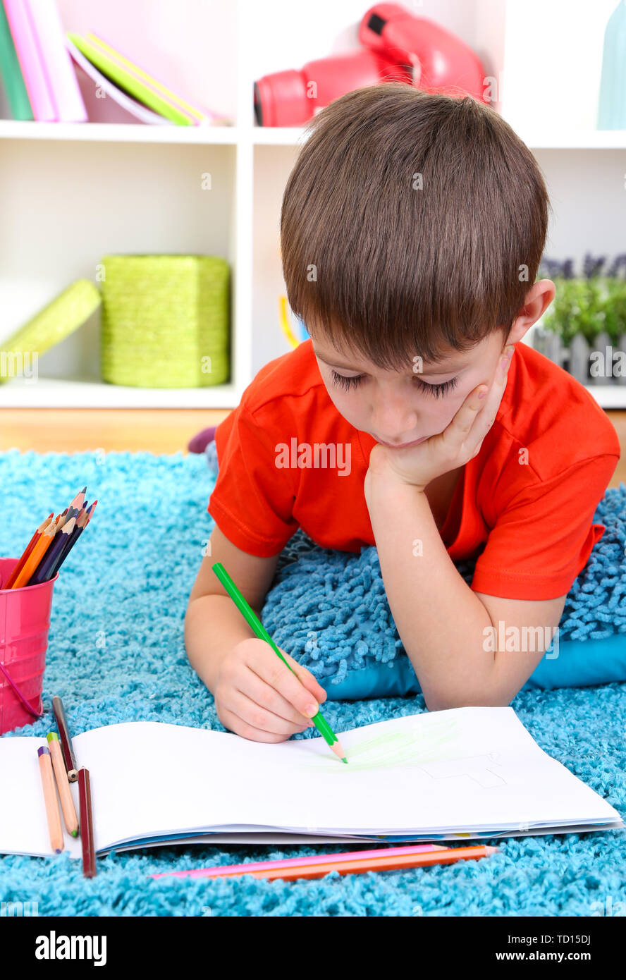 Cute little boy drawing in his album Stock Photo - Alamy
