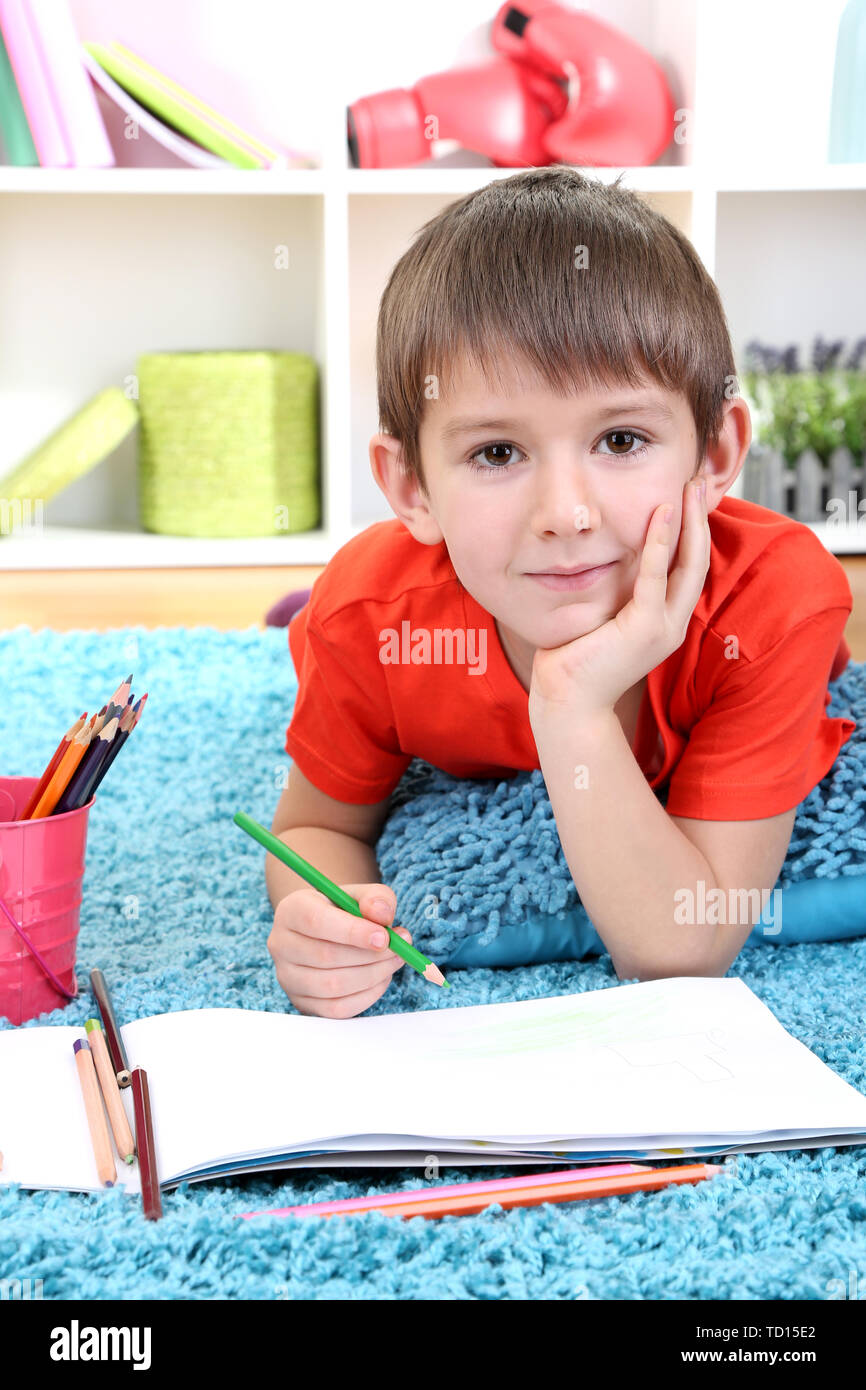 Cute little boy drawing in his album Stock Photo - Alamy