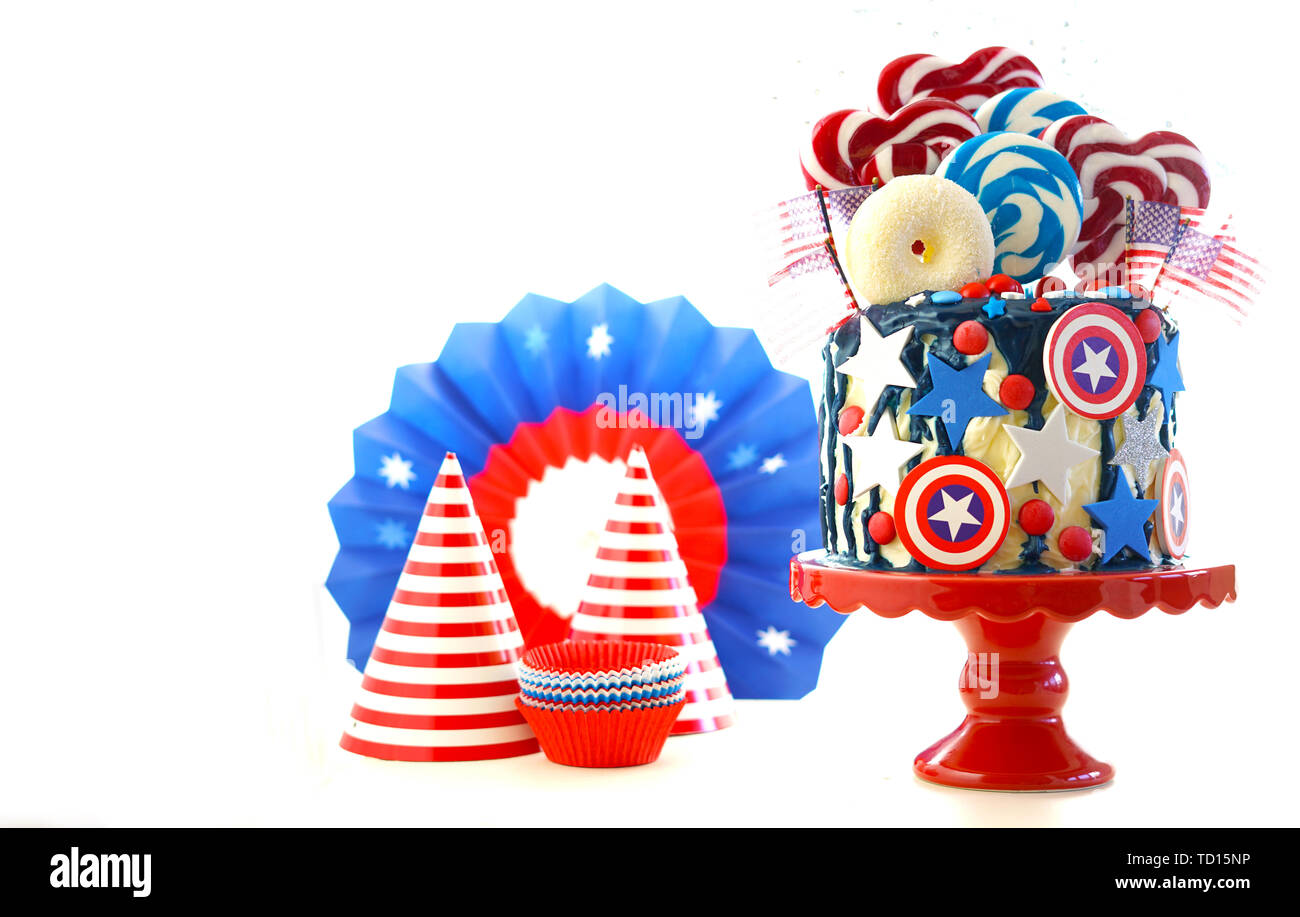 USA theme on-trend candyland fantasy drip cake with decorations on white background. Stock Photo