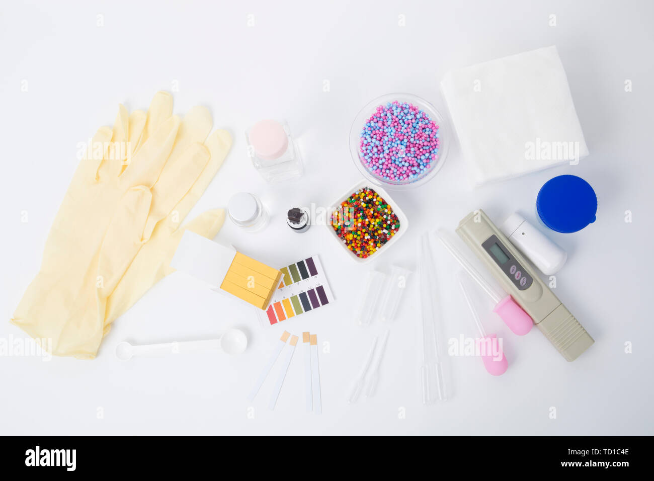 Cosmetics harmful ingredients detection tools, ph test paper, rubber gloves, chemical solution etc on white background Stock Photo