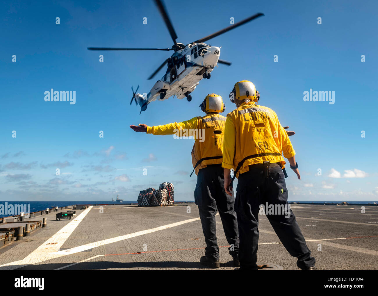 190607-N-WI365-1236 PHILIPPINE SEA (June 07, 2019) – Sailors aboard the amphibious dock landing ship USS Ashland (LSD 48) receive supplies via vertical replenishment (VERTREP) during a replenishment-at-sea (RAS) with the dry cargo and ammunition ship USNS Amelia Earhart (T-AKE-6). Ashland is underway conducting routine operations as part of the Wasp Amphibious Ready Group (ARG) in the U.S. 7th Fleet area of operations. (U.S. Navy photo by Mass Communication Specialist 2nd Class Markus Castaneda) Stock Photo
