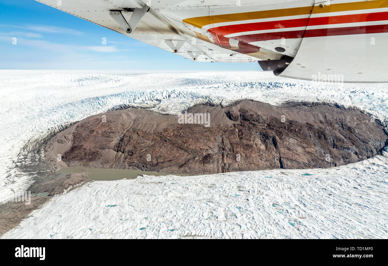 Greenlandic melting ice sheet glacier aerial view from the plane, near