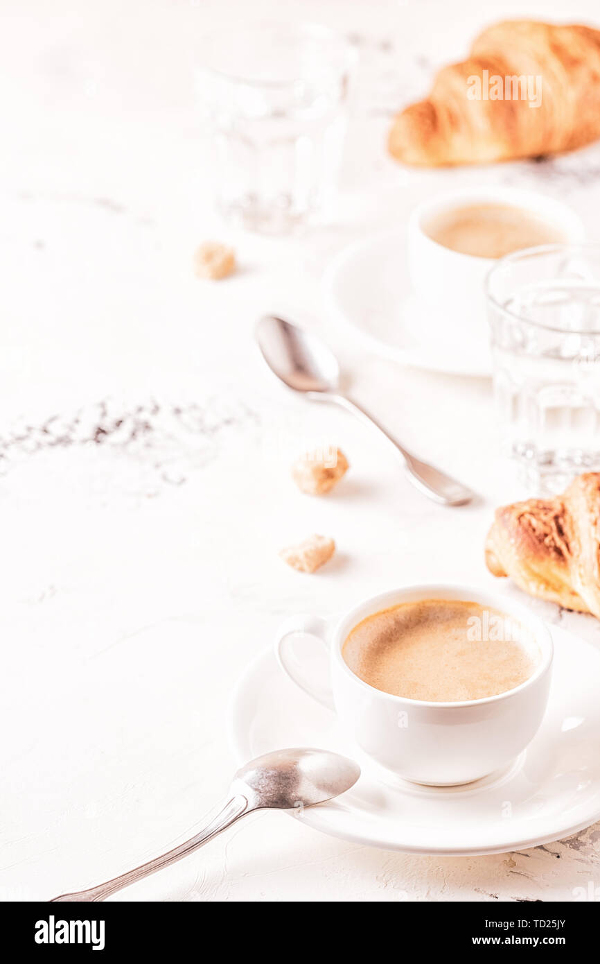 Traditional breakfast with fresh croissants on white background, vertical. Stock Photo