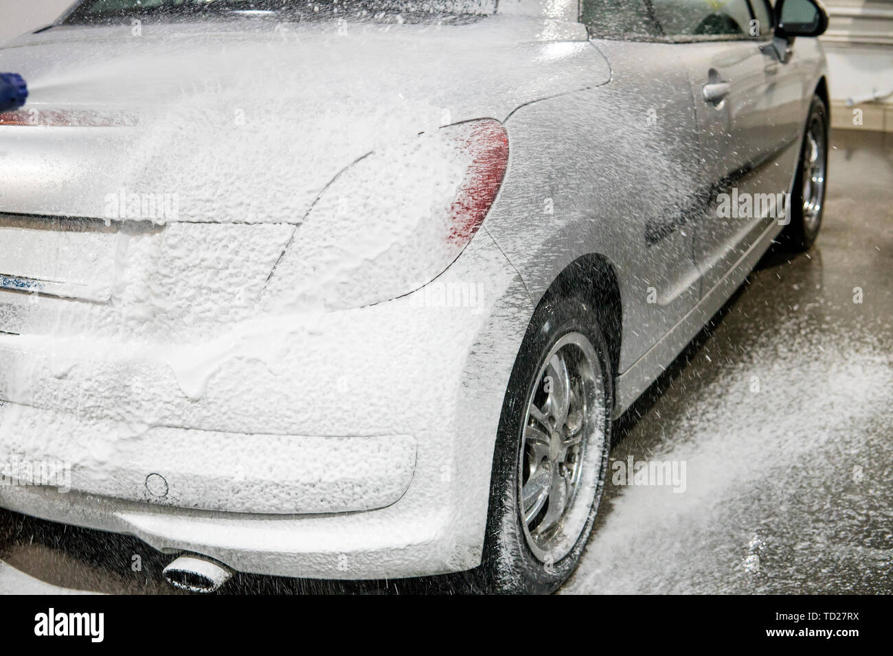 car is covered with foam to wash the car. Automatic car wash. Shampoo for cars. Cleaning process