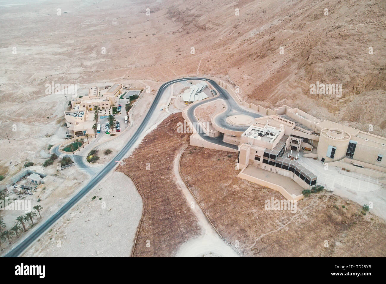 Twisted road and aerial view of well-planned residential area built in the Judean desert, Israel. The oasis with modern infrastructure in badlands of Stock Photo
