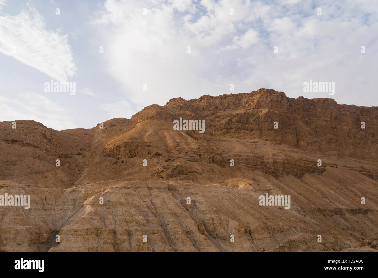 Dusty, dry view of the arid Judean Desert of Israel, at the west bank of the Jordan river. Droughty area and terracotta cliff against the scyscape Stock Photo