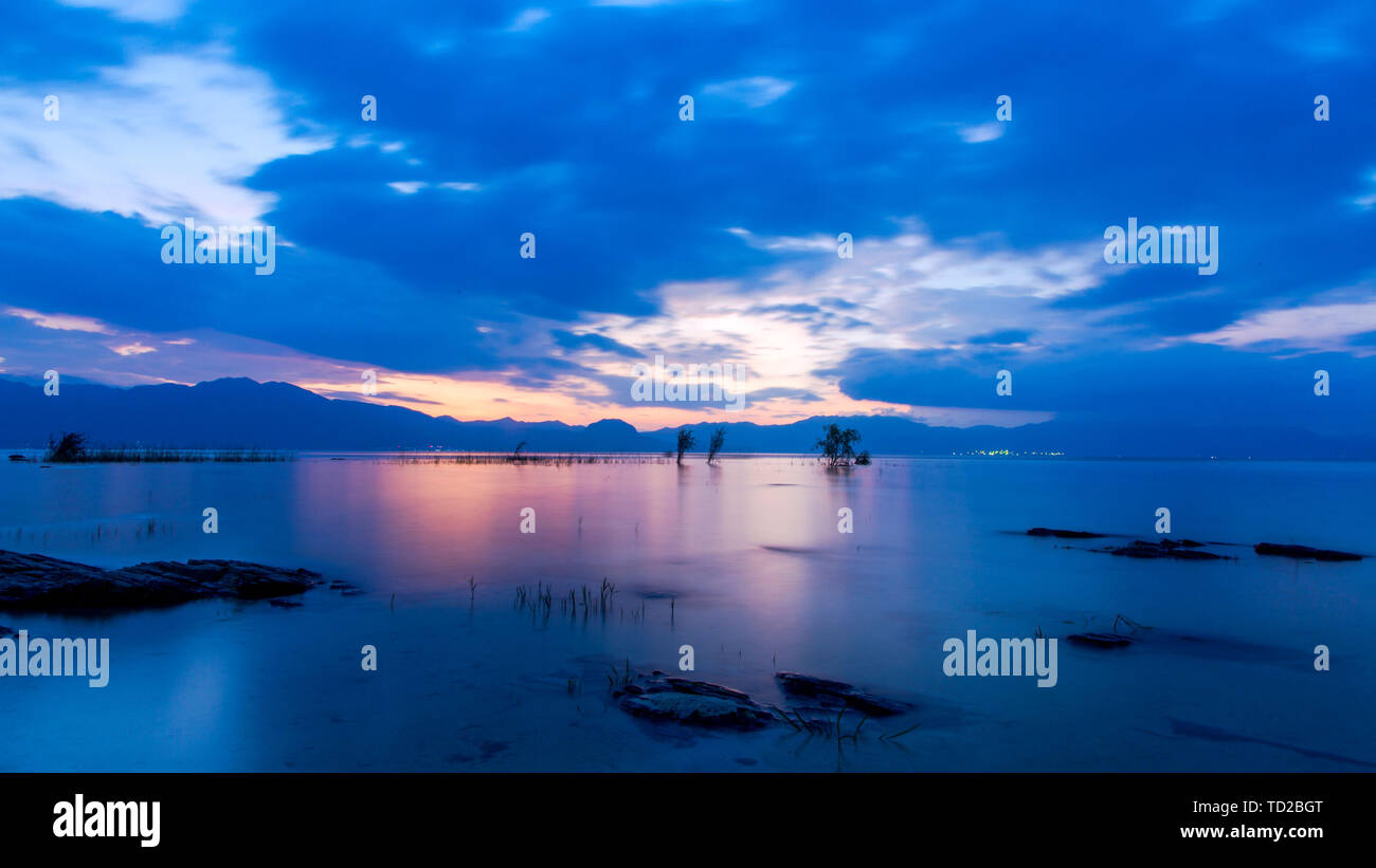 This is a sunset photo taken in Fuxian Lake in Yuxi, Yunnan Province. The beautiful Fuxian Lake is a dream place pursued by many people, and Fuxian Lake at sunset is even more beautiful and unbearable. Stock Photo