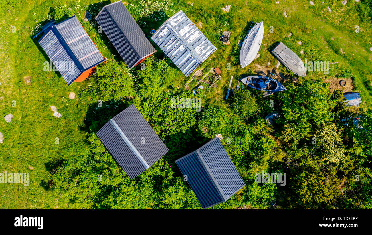 Straight down aerial of fishing sheds and boats among shrubbery. Stock Photo