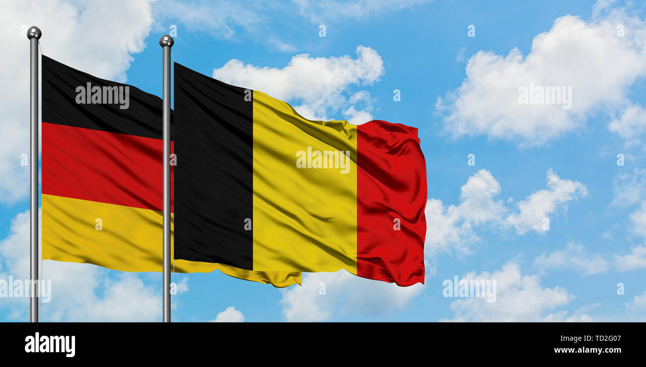 Germany and Belgium flag waving in the wind against white cloudy blue ...