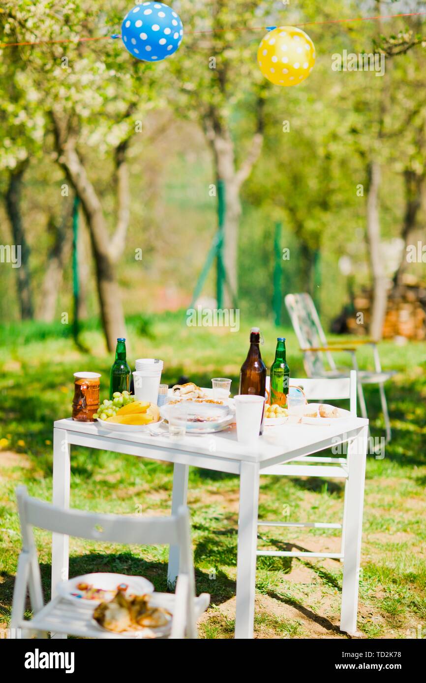 Small table with bottles of beer and food on summer garden party Stock ...