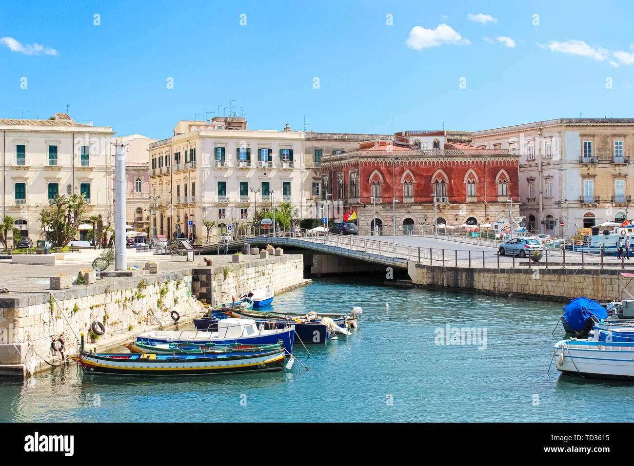 Syracuse, Sicily, Italy - Apr 10th 2019: Beautiful small harbor and boats between Syracuse city and Ortygia Island captured on a sunny day. Popular tourist destination. Stock Photo