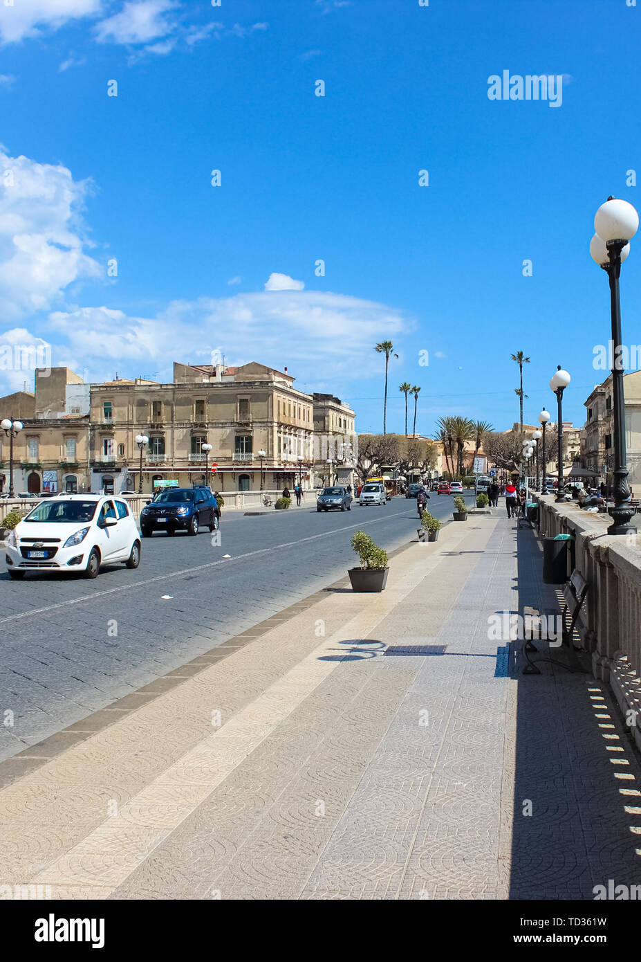 Syracuse, Sicily, Italy - Apr 10th 2019: Vertical photo of bridge that is connecting Syracuse city and Ortygia Island. Taken on sunny day with driving cars. Beautiful Ortigia is popular tourist place. Stock Photo