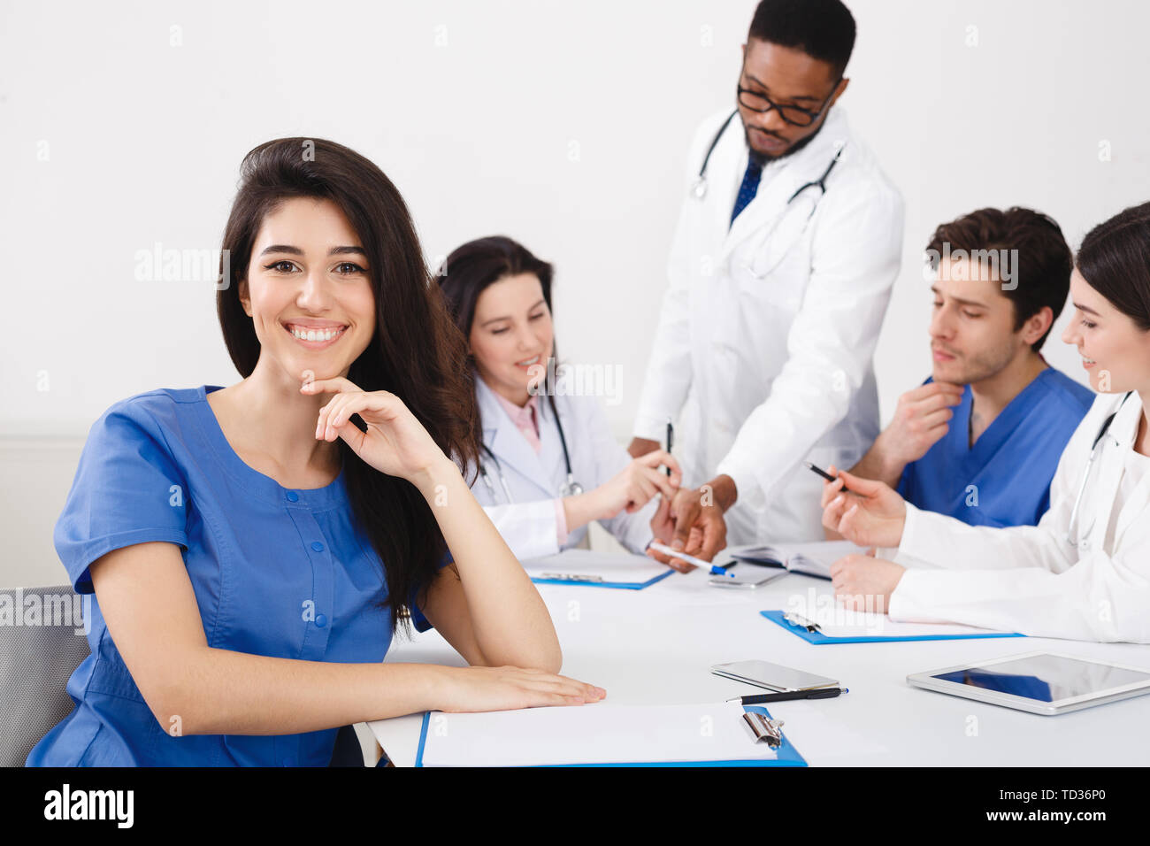 Meeting Of Medical Pros. Nurse Smiling To Camera At Meeting Stock Photo