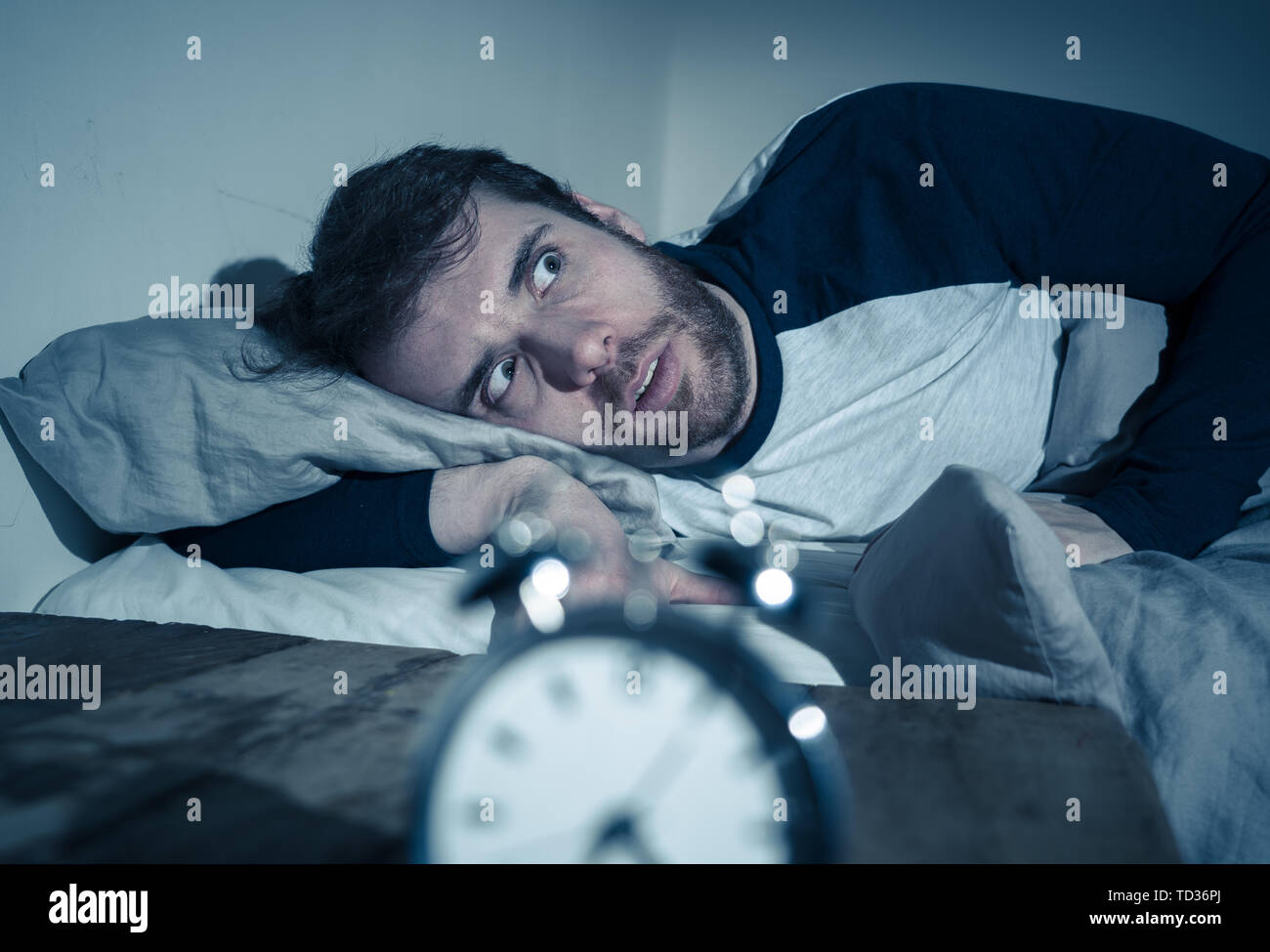 Insomnia Stress and Sleeping disorder concept. Sleepless desperate young caucasian man awake at night not able to sleep, feeling frustrated and worrie Stock Photo