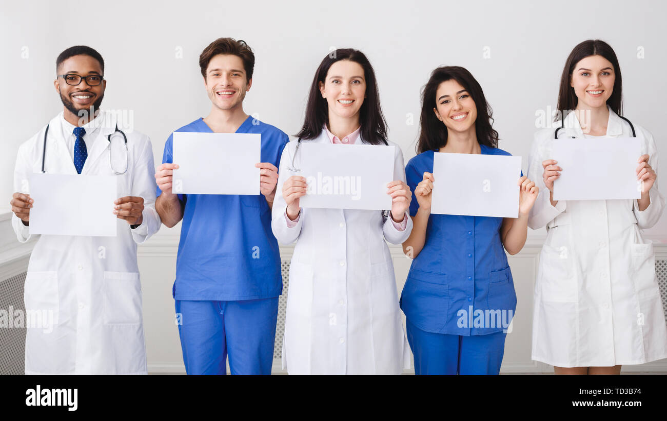 Doctors And Interns Holding Empty Papers, Standing In Hospital Stock Photo
