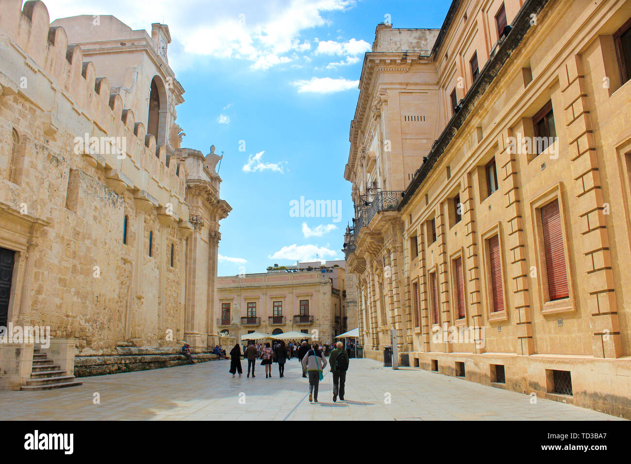 Syracuse, Italy - Apr 10th 2019: People walking to the Piazza Duomo Square along beautiful Roman Catholic Cathedral of Syracuse in Ortigia Island, Sicily, Italy. Popular tourist place. Stock Photo