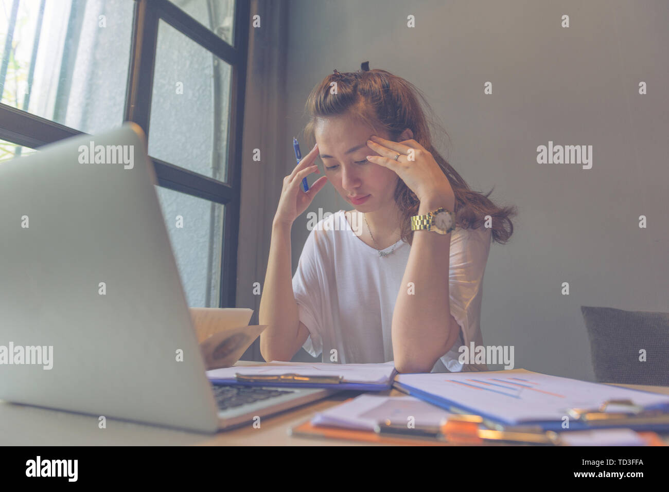 Young beautiful lady focus on reading documents while working Stock Photo