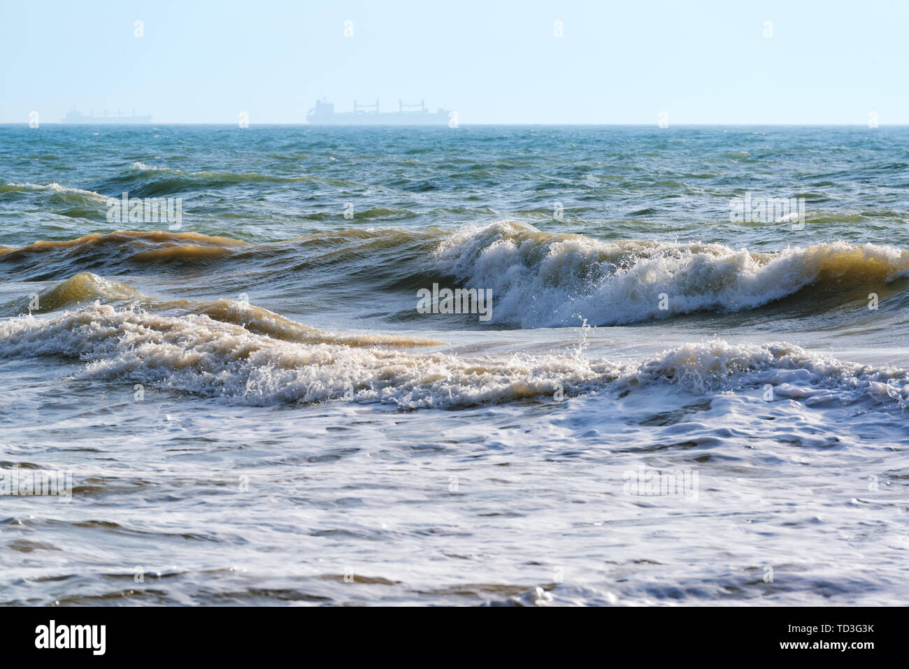 Sea with waves and ships silhouettes on the horizon Stock Photo - Alamy