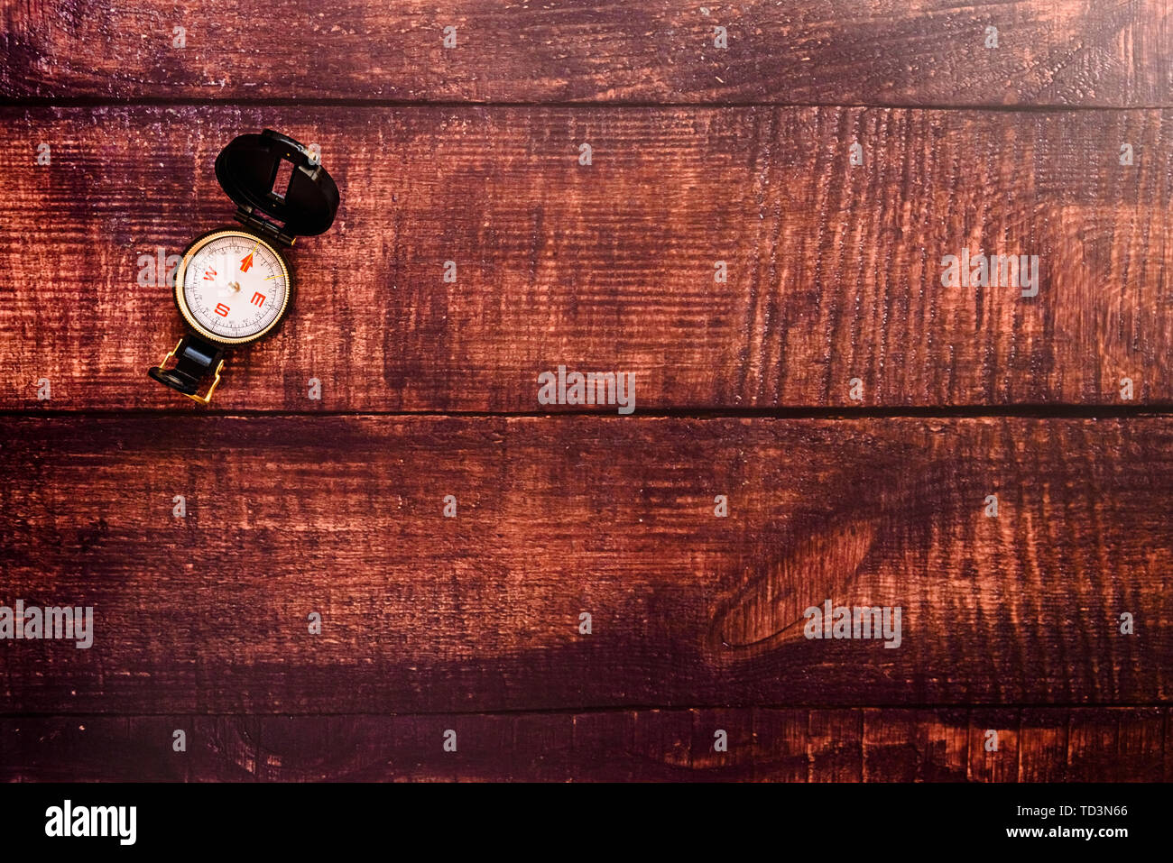 Isolated compass on a brown aged wooden table. Stock Photo