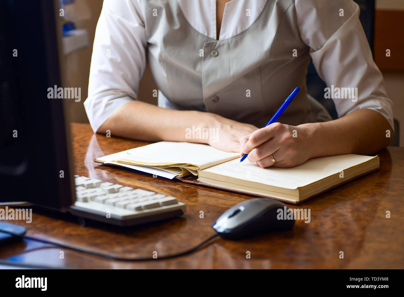 doctor woman writes in the diary of current Affairs in the dental clinic Stock Photo