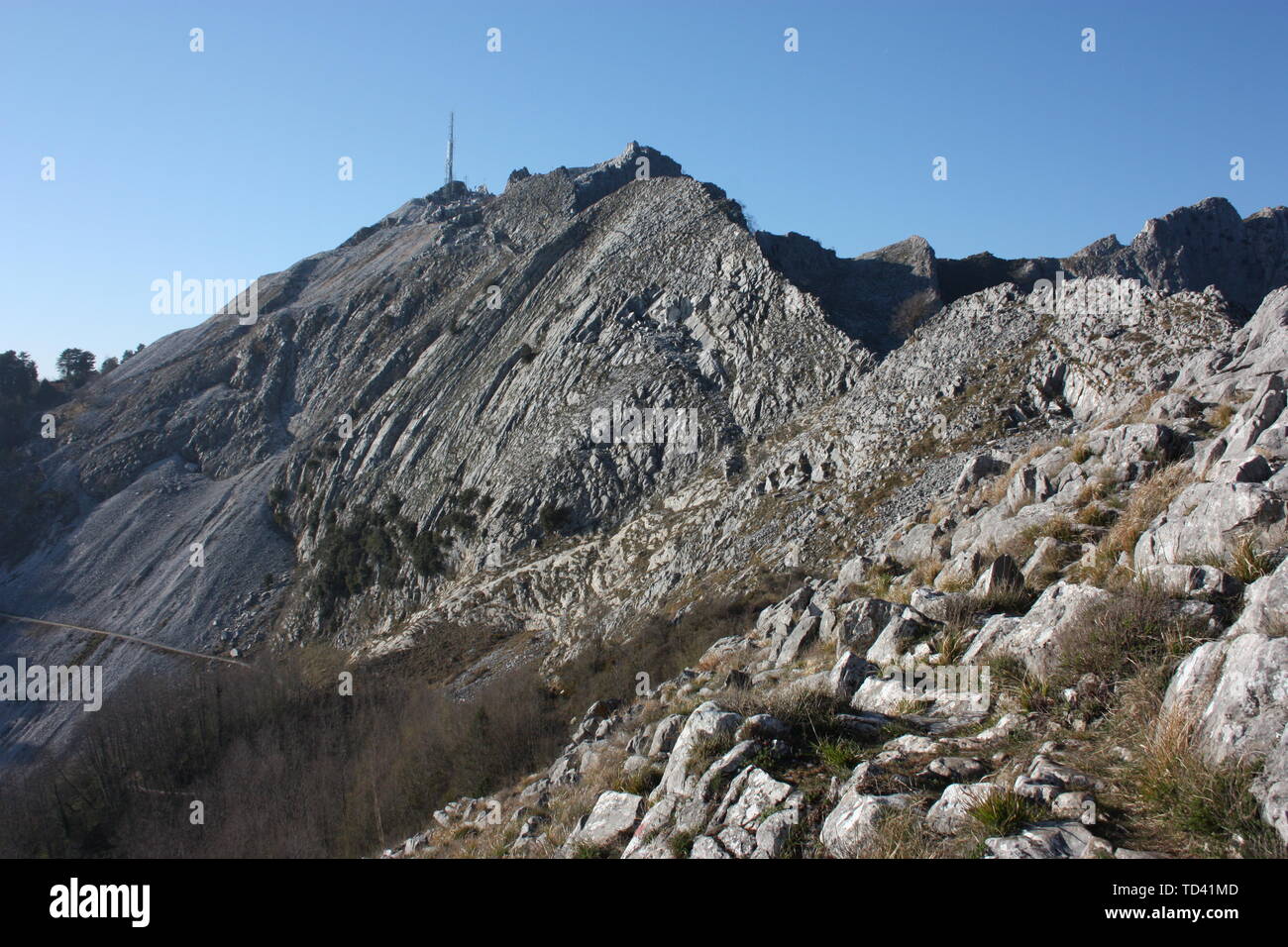 one side of the peaks of the mountains of the Tuscan Apuan Alps in Montignoso. Rocky Apennines on a summer day Stock Photo