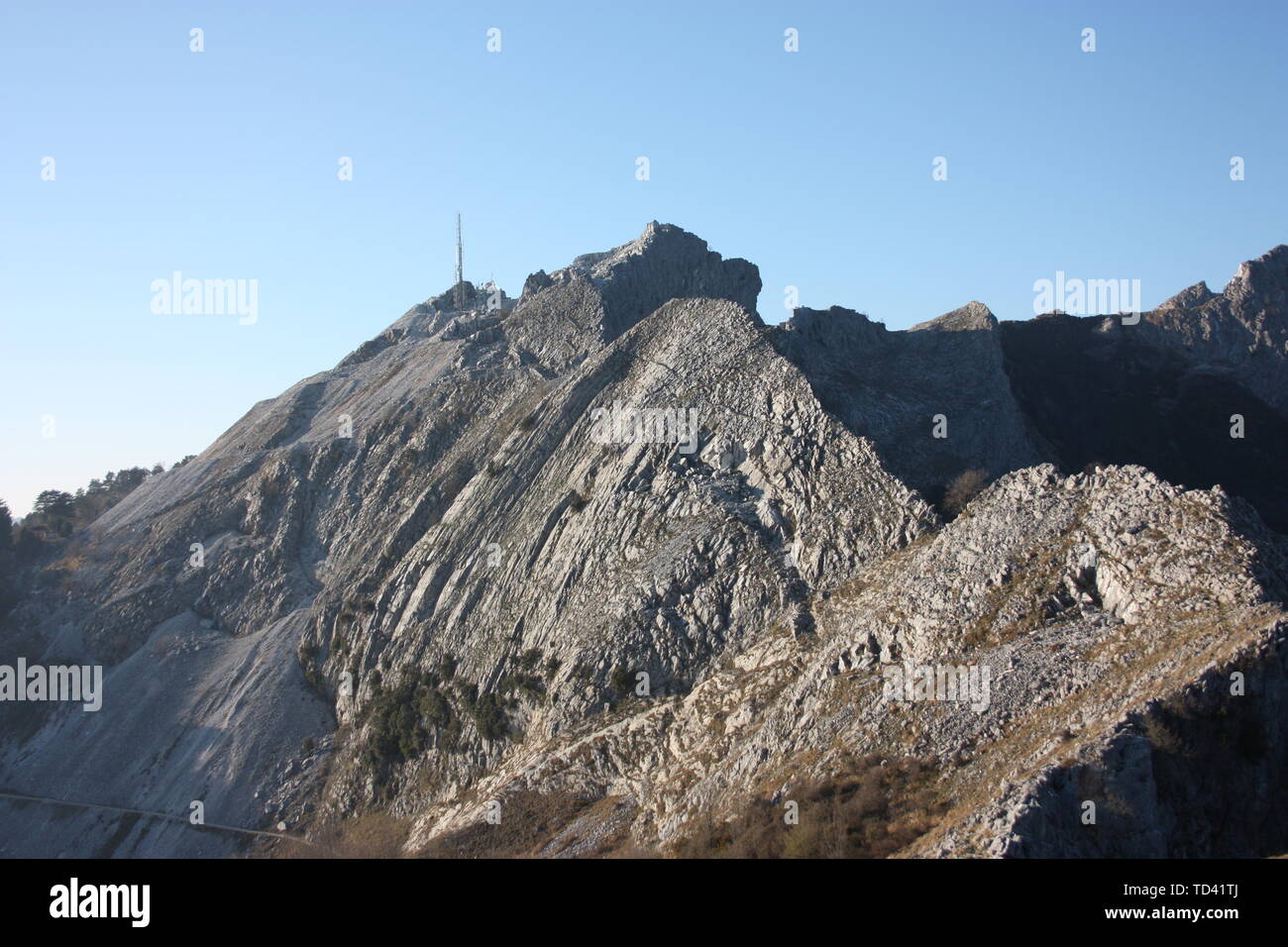one side of the peaks of the mountains of the Tuscan Apuan Alps in Montignoso. Rocky Apennines on a summer day Stock Photo