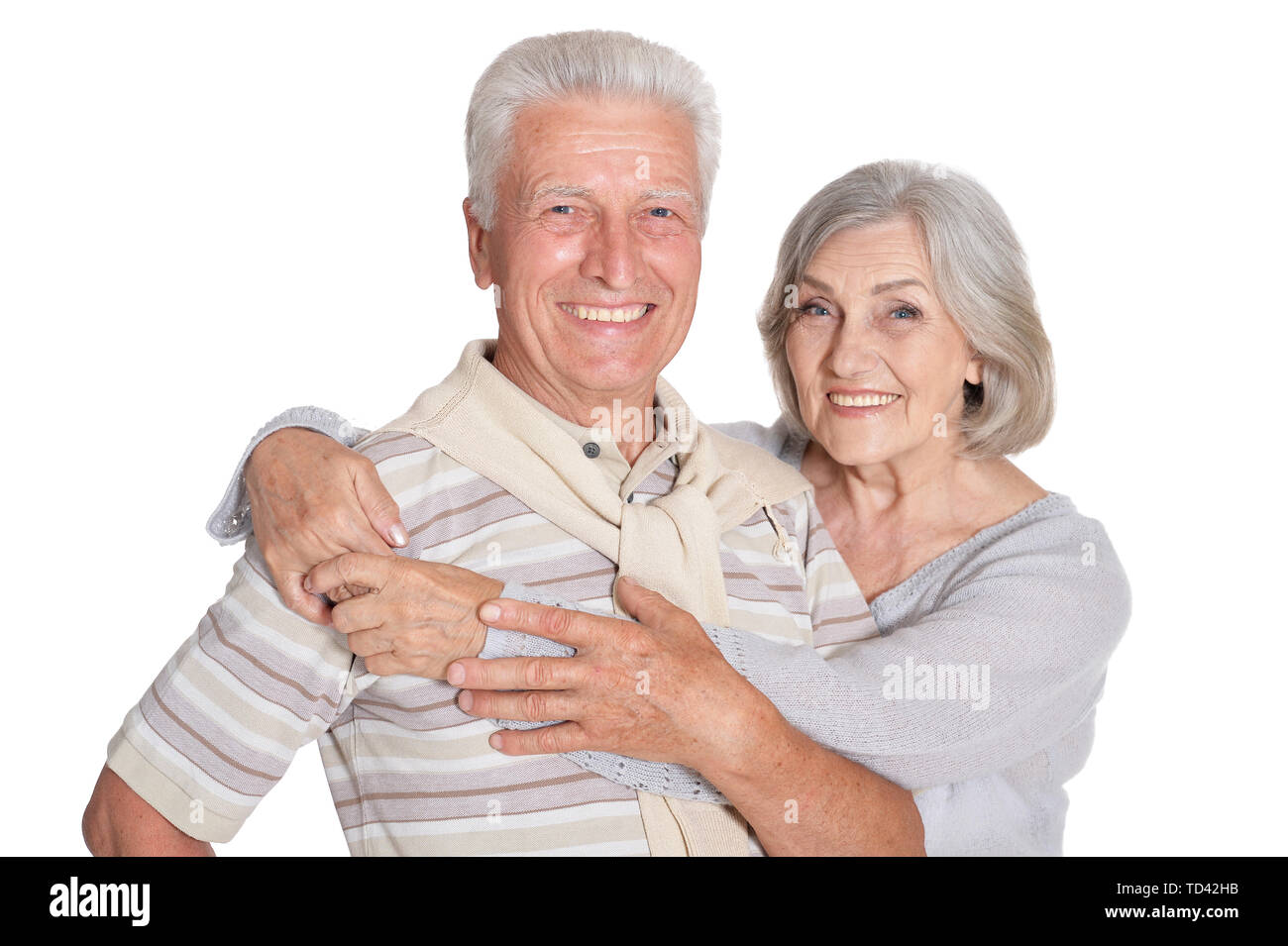 Portrait of happy senior couple hugging on white background Stock Photo