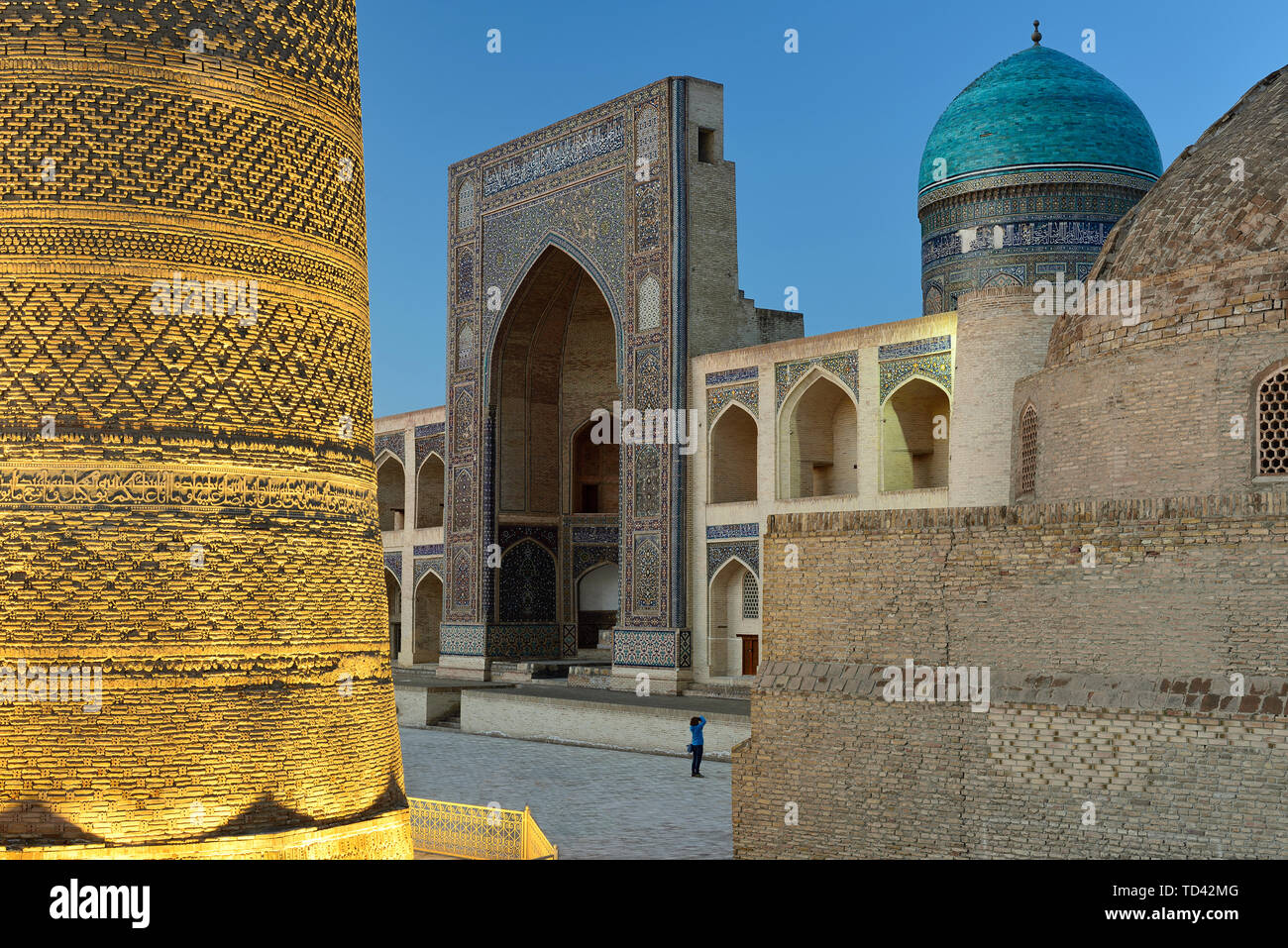 The tourist is making the photograph on the  main square in Bukhara where is Mir-i-Arab Medressa and Kalyan minaret, Uzbekistan. Stock Photo