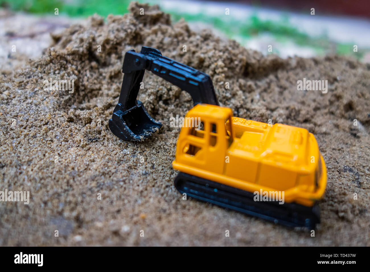 Lower model of excavator digging in sand Stock Photo - Alamy